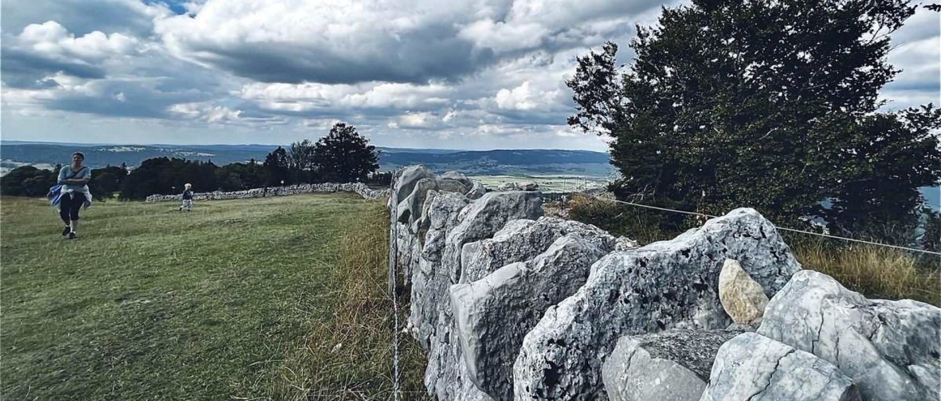 Mur du pierre typique du Jura sur le plateau du Creux du Van avec paysage naturel du Val de Travers