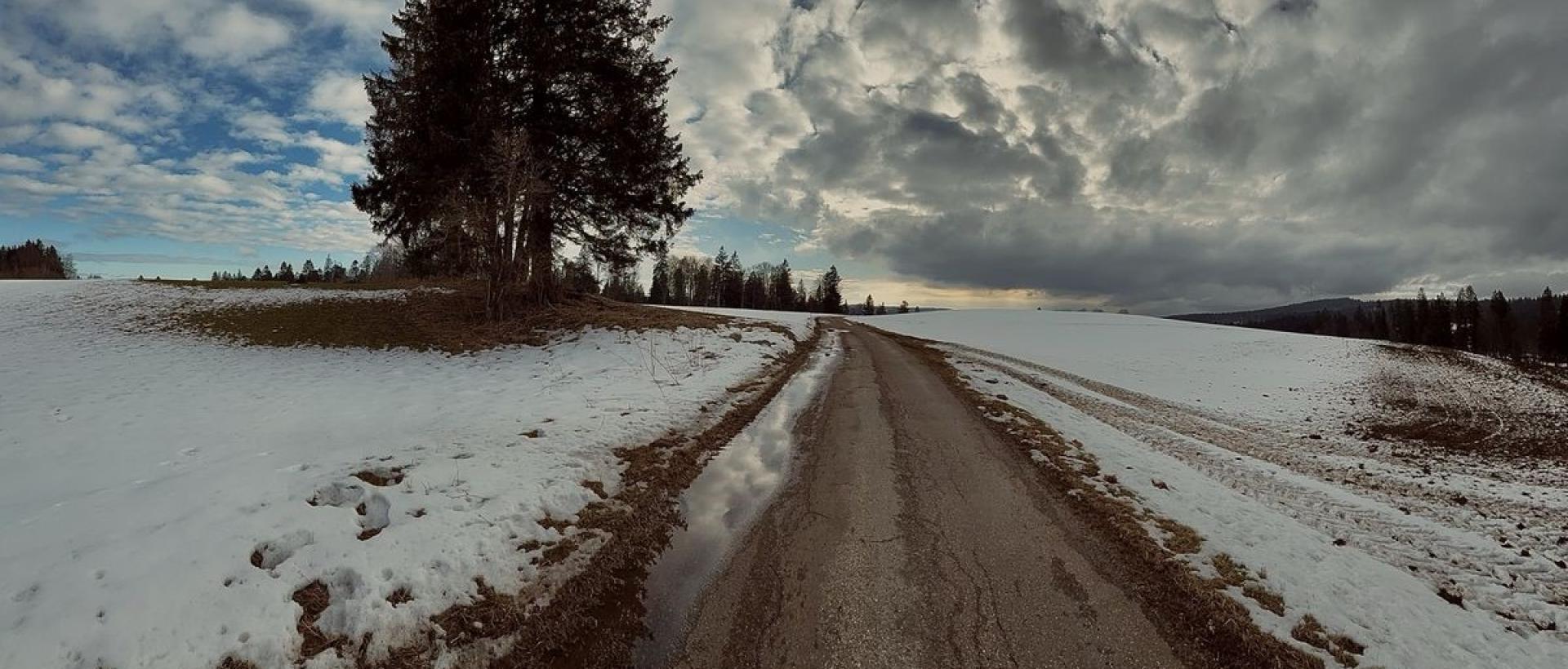 Route enneigée et paysage du Jura neuchâtelois au Val-de-Travers près de l'Hôtele Les Cernets
