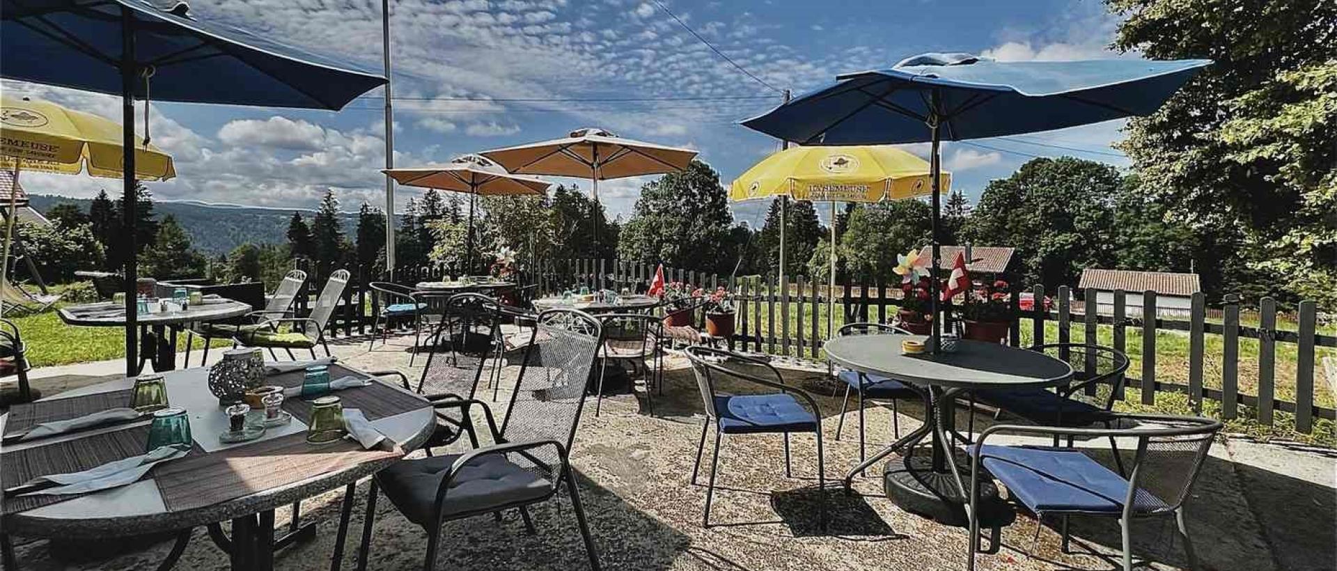 Terrasse du restaurant de l'Hôtel Les Cernets dans le Jura suisse avec vue nature au Val de Travers