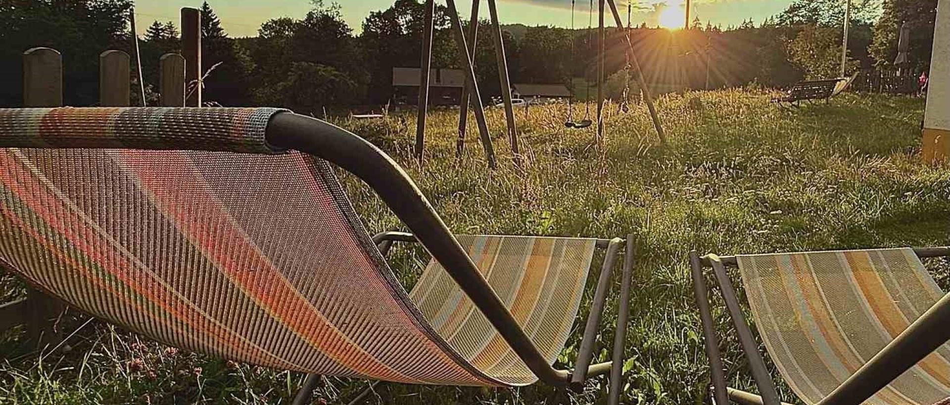 Transats face au coucher de soleil à l'Hôtel Restaurant Les Cernets dans le Jura suisse