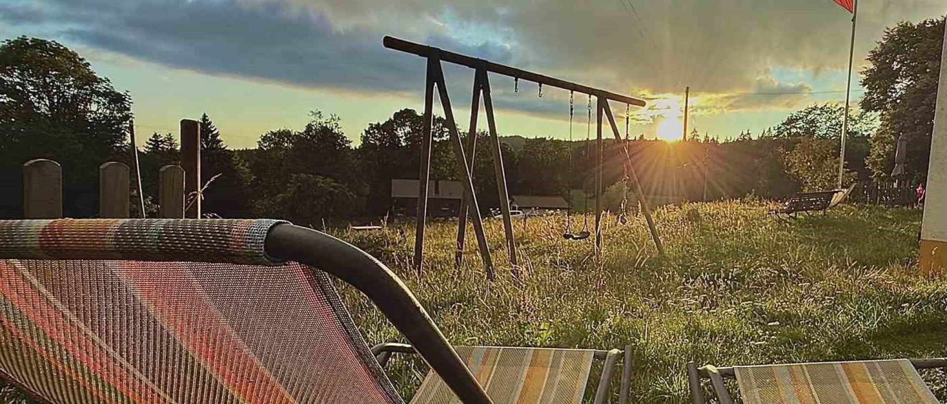 Transats face au coucher de soleil à l'Hôtel Restaurant Les Cernets dans le Jura suisse