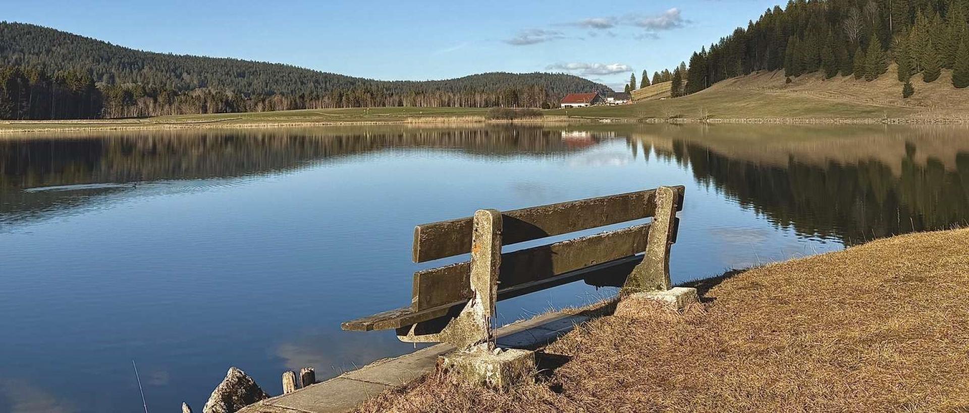 Banc face au lac des Taillères dans le Jura suisse panorama Val-de-Travers