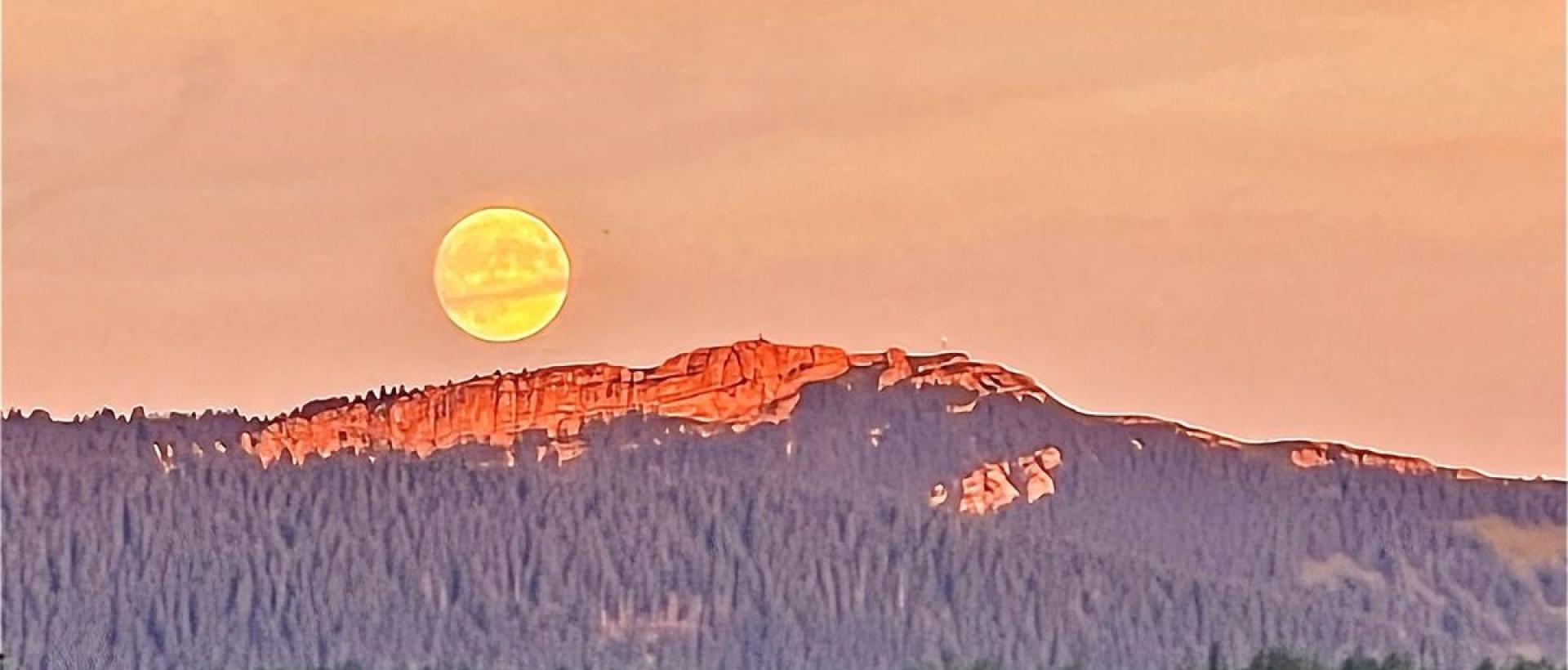 Pleine lune se levant sur le Chasseron au-dessus de Val-de-Travers, vue depuis l'Hôtel Les Cernets dans le Jura suisse
