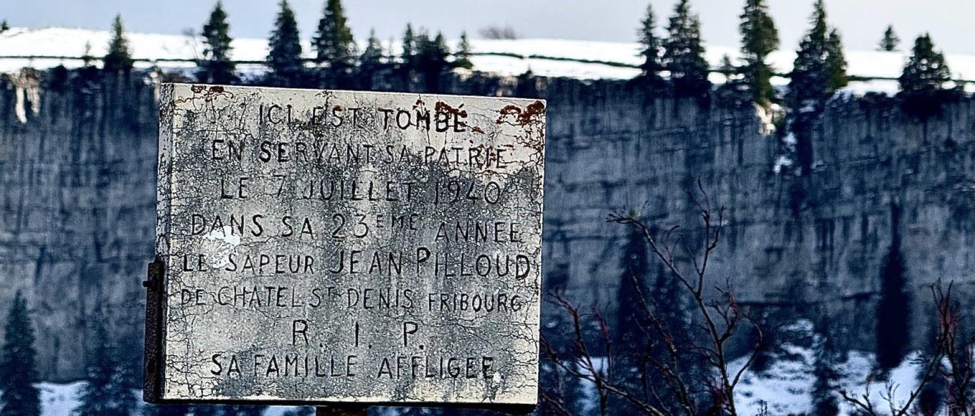 plaque commémorative d'un soldat au Creux d Van avec falaises en arrière-plan Val-de-Travers Jura suisse