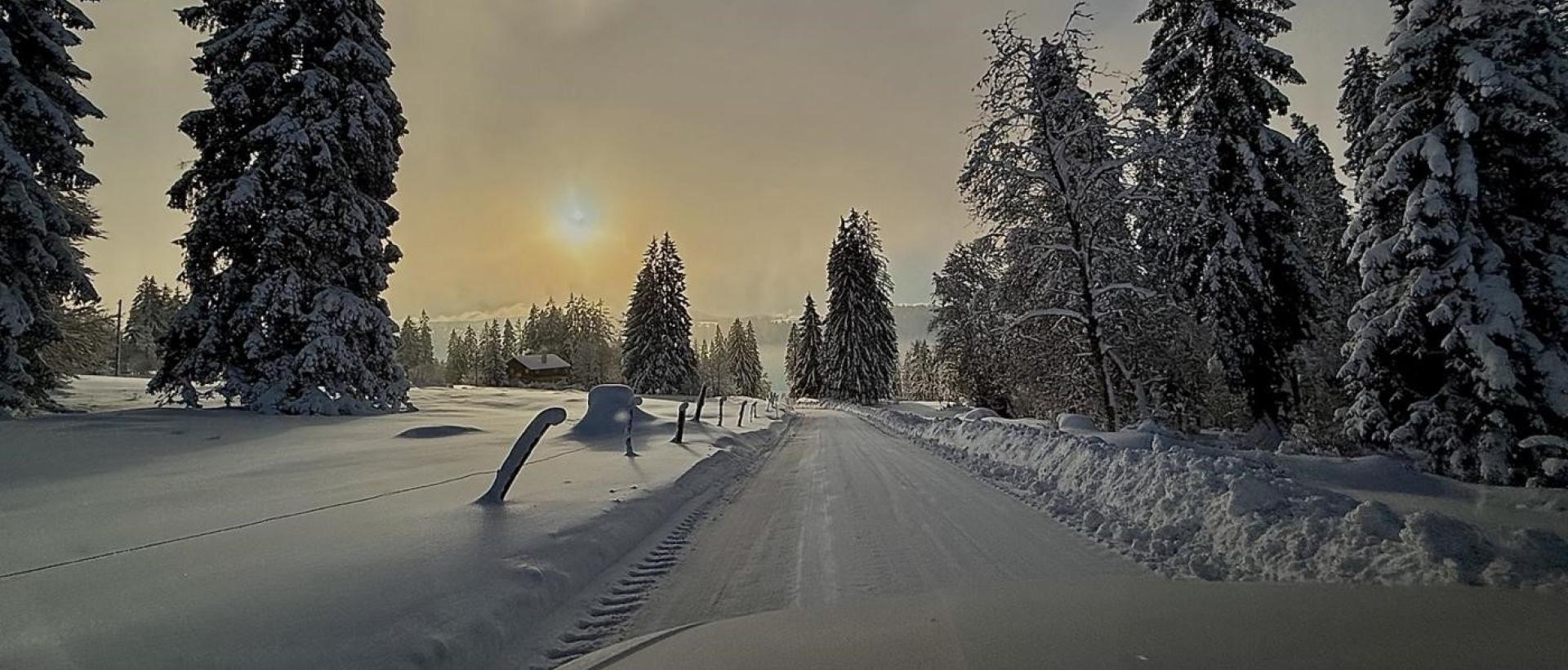 Paysage hiver Jura suisse Val-de-Travers route neige coucher soleil