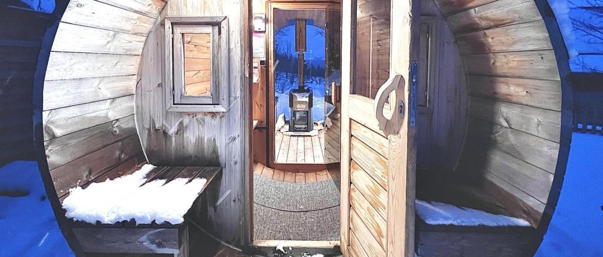 Sauna panoramique extérieur en hiver chauffé au feu de bois à l'Hôtel Les Cernets Jura suisse