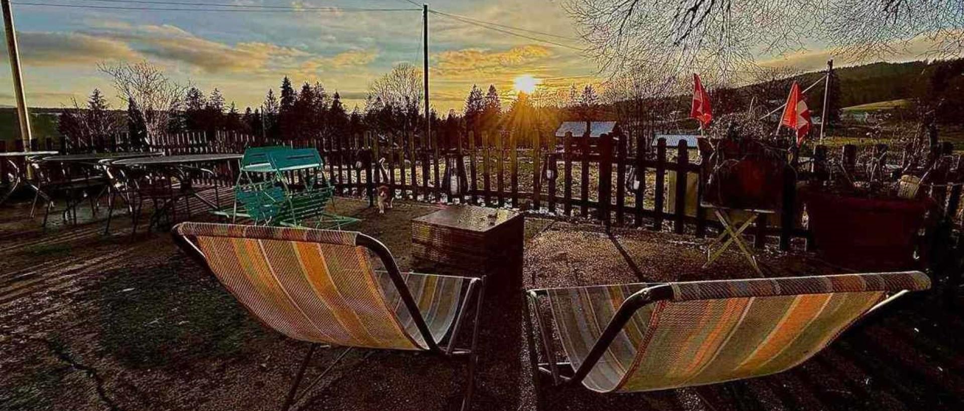 Terrasse de l'Hôtel Les Cernets au coucher de soleil dans le Jura suisse au Val-de-Travers