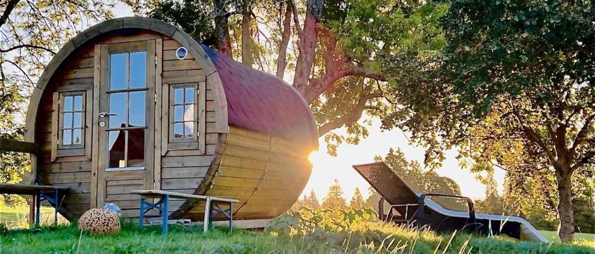 Tiny House écologique en pleine nature au Val-de-Travers avec terrasse et transats au levé du soleil