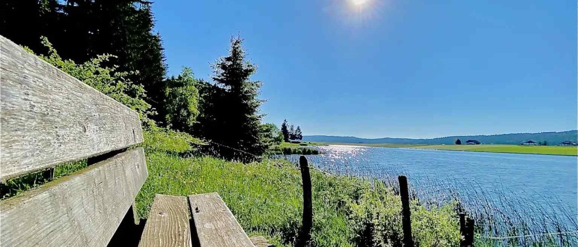 banc avec vue sur le lac des Taillères au printemps dans le val-de-travers