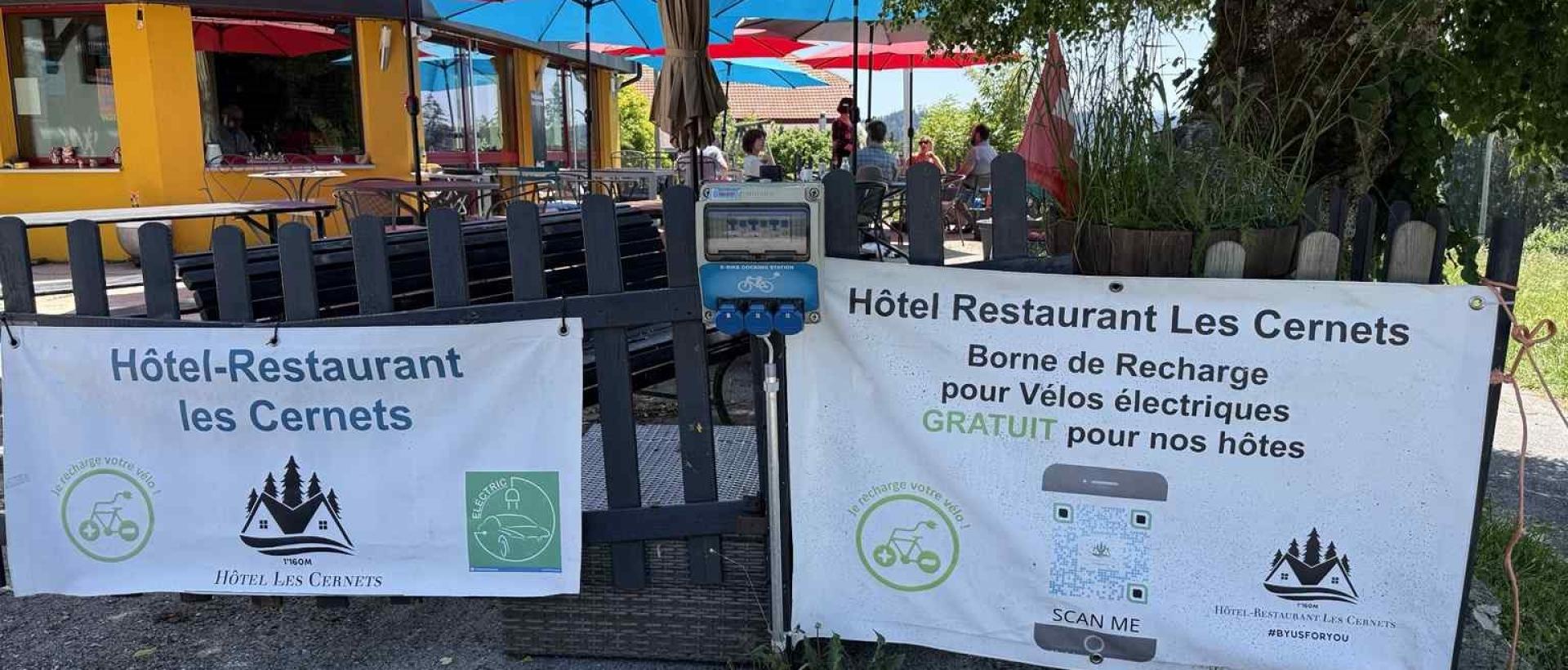 Borne de recharge pour vélos électriques à l'Hôtel Restaurant Les Cernets dans le Val de Travers, étape idéale pour cyclotouristes et voyageurs du Jura suisse