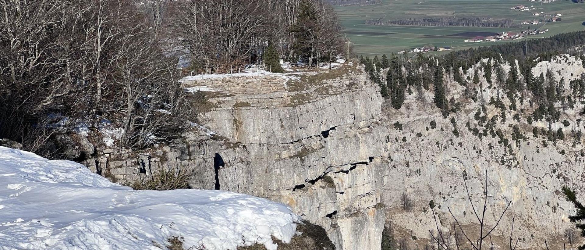 Creux du Van en hiver, falaises calcaires et neige, vue sur la la vallée de la Sagne