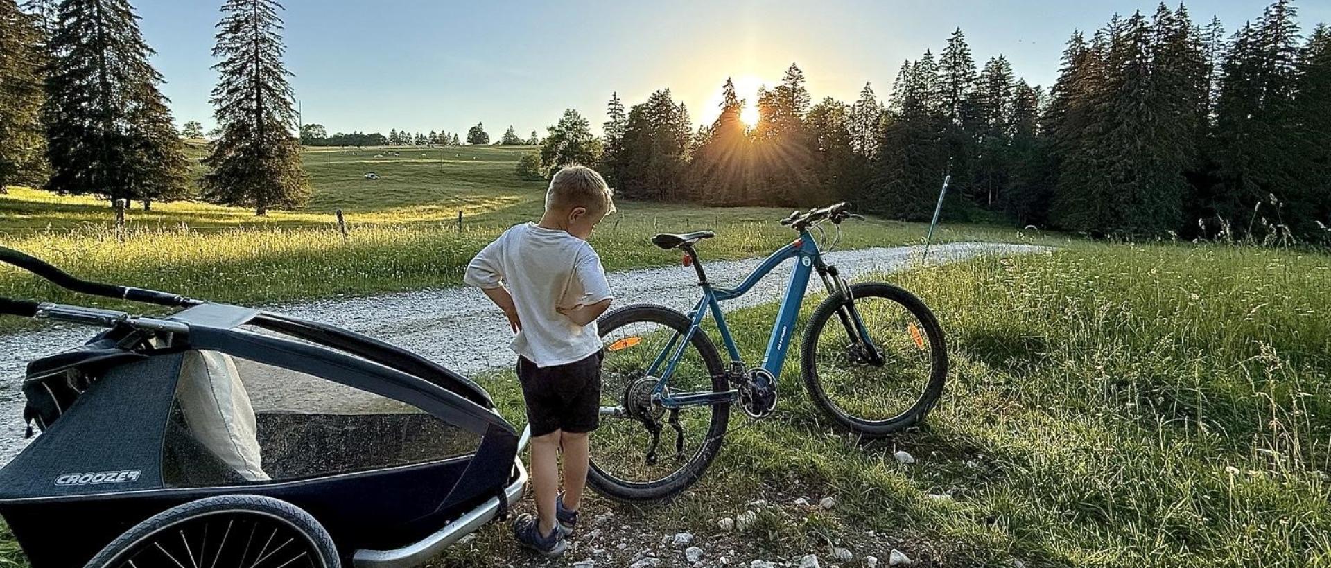 Coucher de soleil dans le Val-de-Travers aux Cernets enfant et vélo électrique