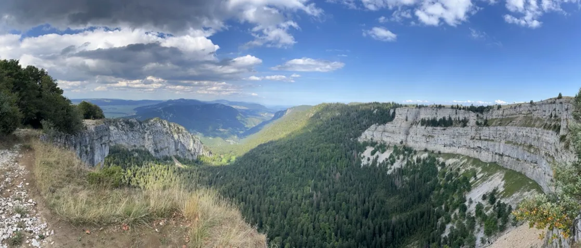 Panoramique du Creux du Van dans le Val-de-Travers avec falaises calcaires, forêts du Jura neuchâtelois et vue spectaculaire sur la vallée 