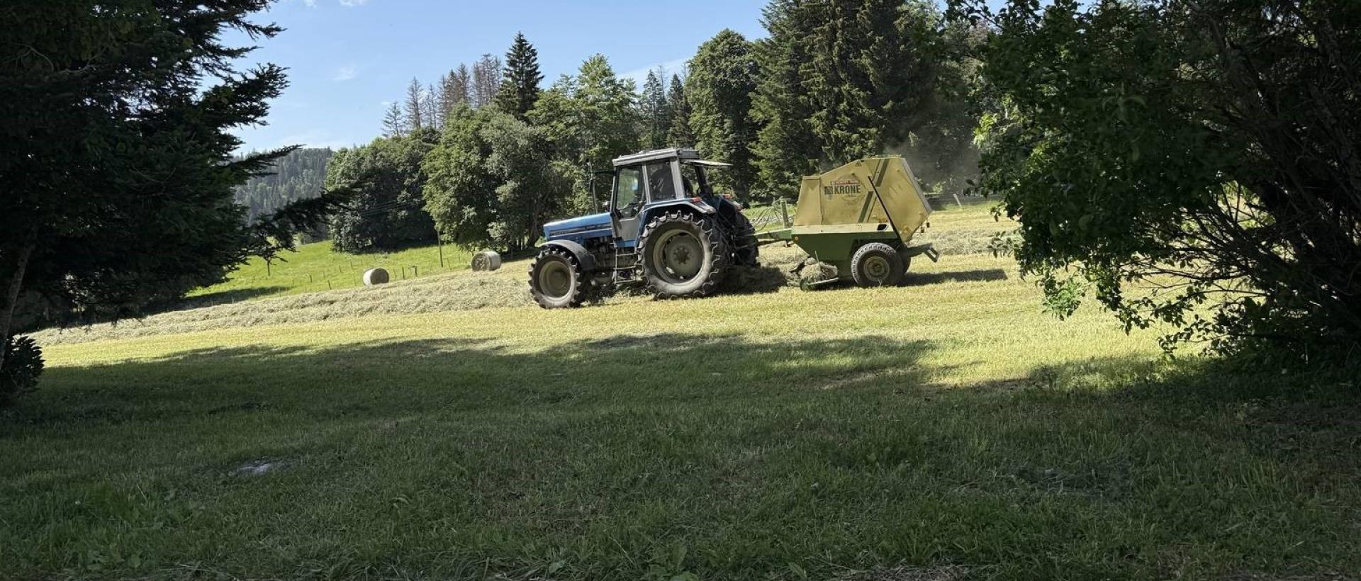 Tracteur agricole pendant la récolte du foin dans le Val de Travers