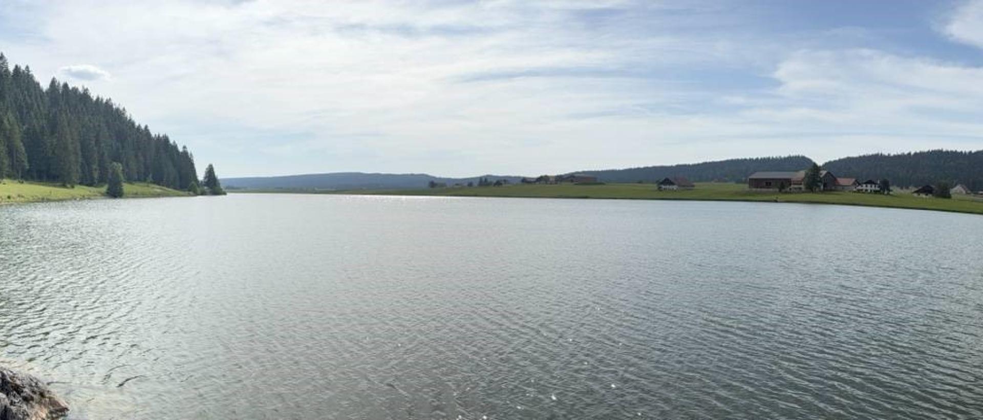 Grand Panorama du Lac des Taillères dans le Jura suisse, entre pâturages, forêts et fermes typique de la Vallée de la Brévine