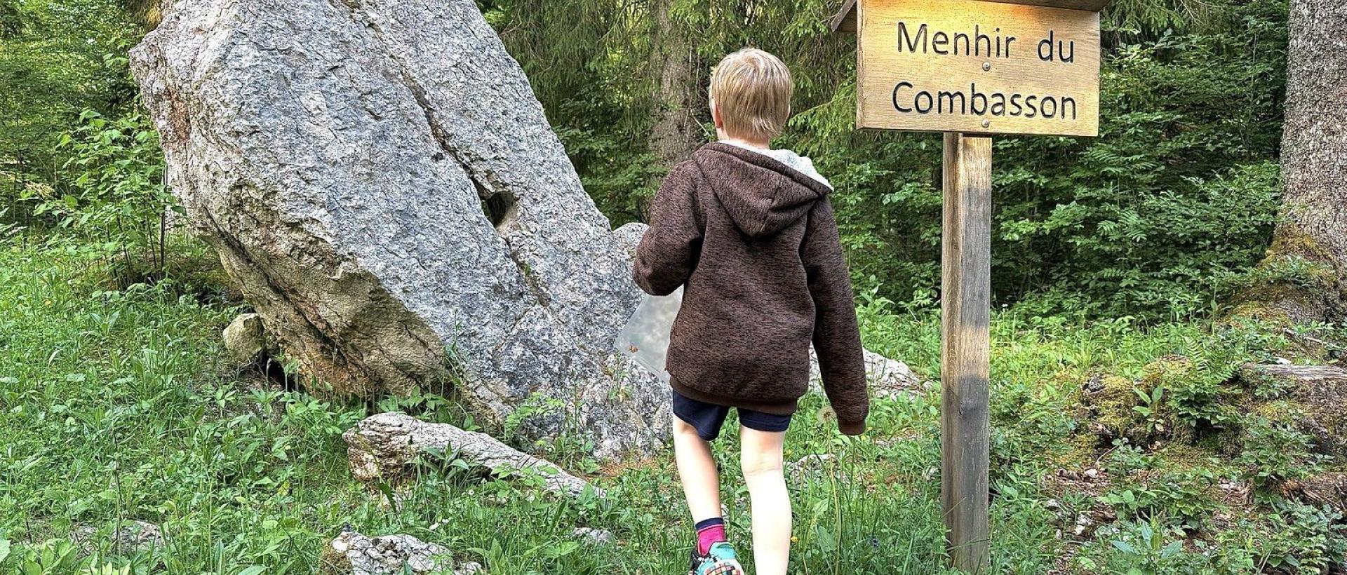 Famille découvrant le Menhir du Combasson aux Cernets