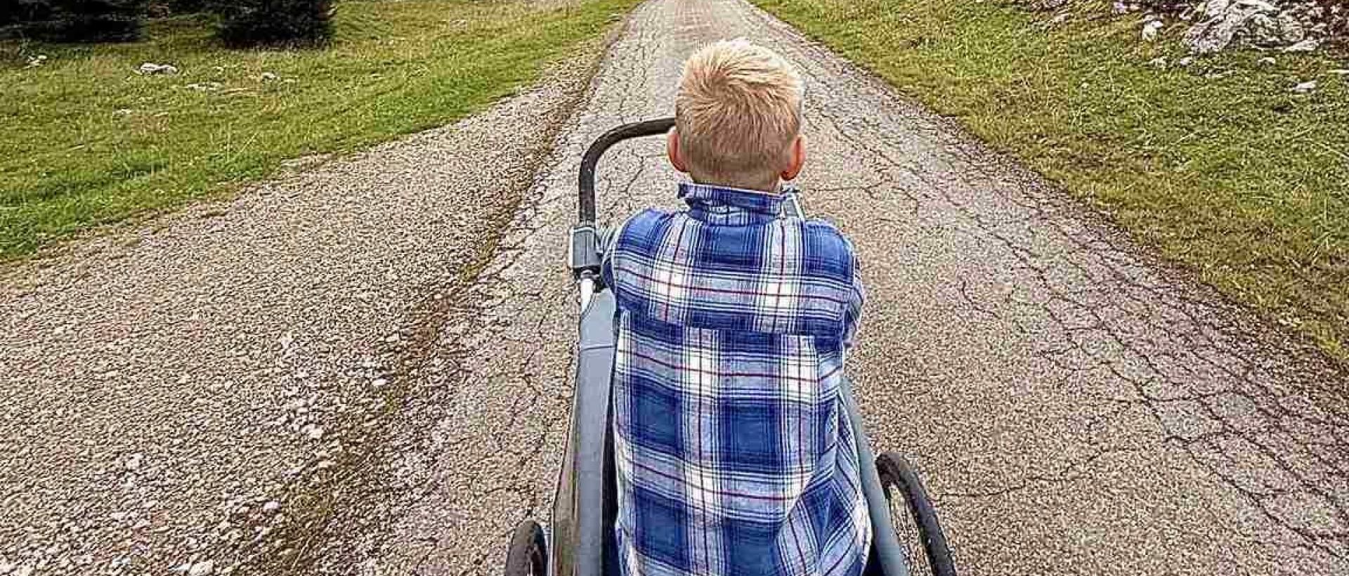 Enfant sur une remorque de vélo découverte des prairies du Jura neuchâtelois