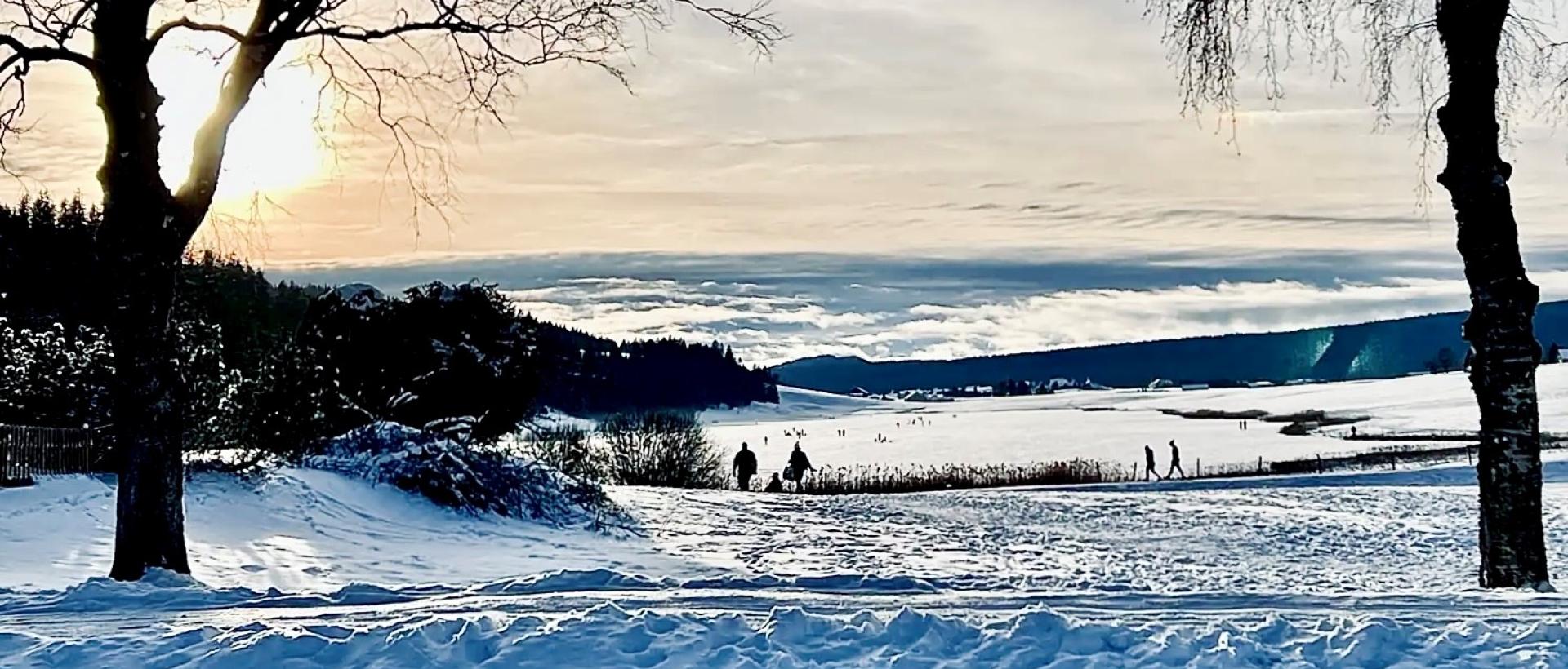 Vue panoramique du lac des Taillères en hivers au coucher de soleil dans le Val de Travers proche de l'Hôtel Les Cernets