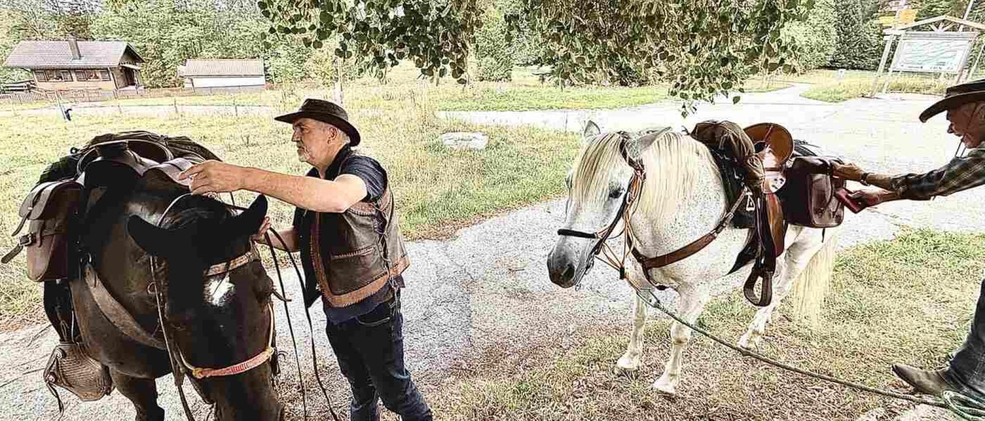 Deux cavaliers préparent leurs chevaux lors d'une halte à l'Hôtel Les Cernets dans le Jura suisse