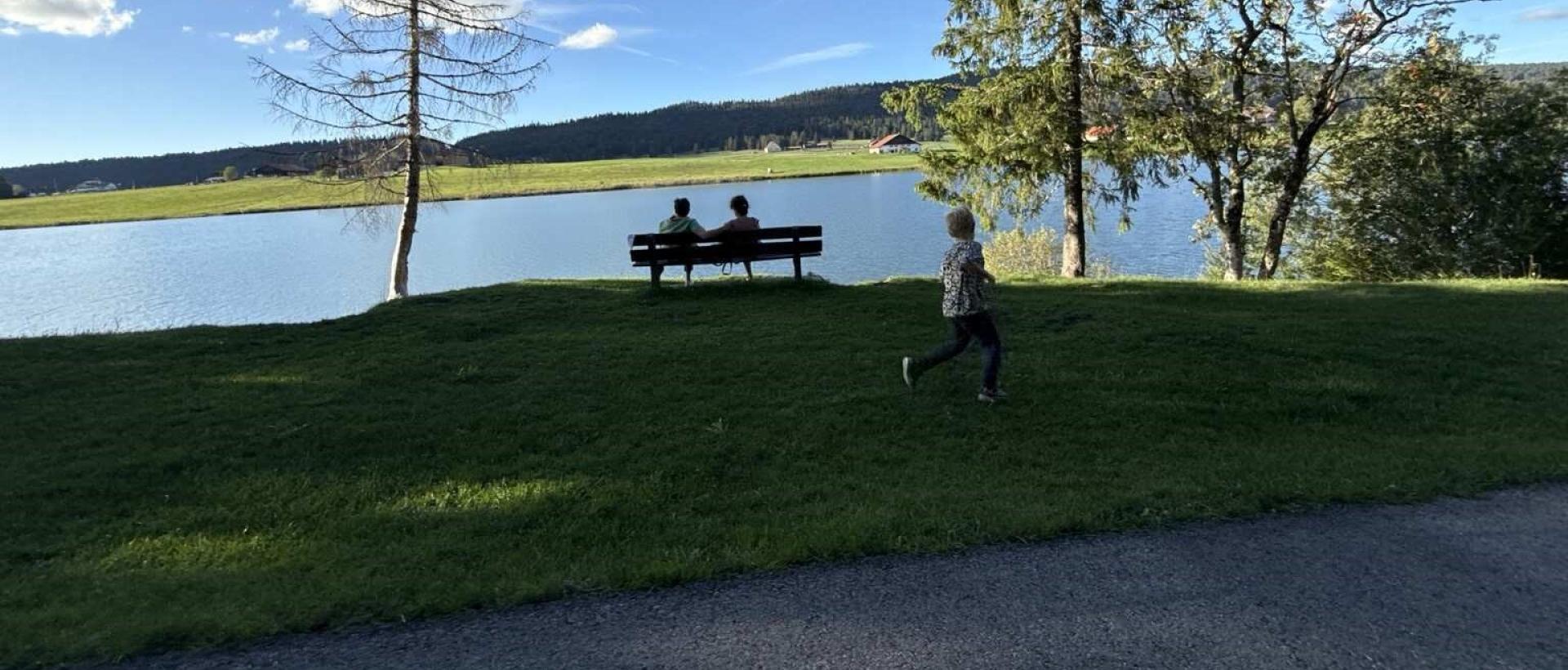 Famille profitant du lac des Taillères lors d'une promenade dans la vallée de la Brévine, au coeur du Jura neuchâtelois