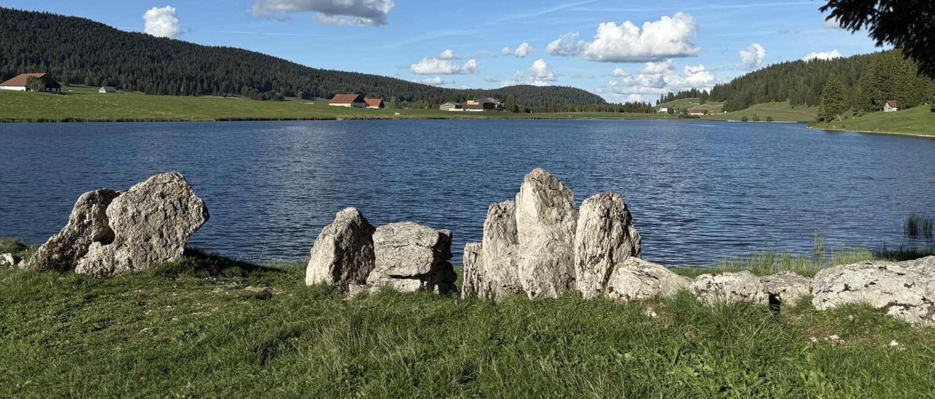 Rive du lac des Taillères face aux fermes de la vallée de la Brévine, dans le Jura suisse