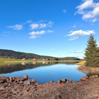 lac des tailleres sapins printemps reflets fermes neuchateloises nuages val de travers