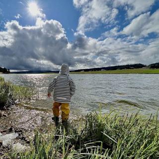 enfant au bord du lac des taillères dans le Jura suisse au Val-de-Travers