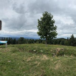 Panneau de randonnée sur la GTJ dans le Jura français, paysage ouverts aux Cernets