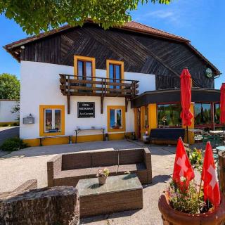 Terrasse extérieure de l'Hôtel Restaurant Les Cernets dans le Val-de-Travers, Jura suisse, avec espace détente et environnement nature