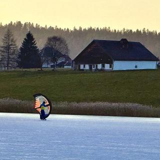 pratique de l'ice kite sur le lac gelé des Taillères dans le Jura suisse