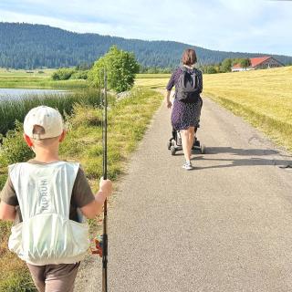 Famille en promenade au bord du lac des Taillères dans la Vallée de la Brévine, paysage naturel du Jura suisse proche de l'Hôtel Restaurant Les Cernets 