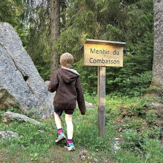 Famille découvrant le Menhir du Combasson aux Cernets
